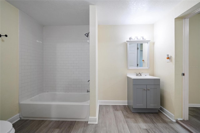 full bathroom with toilet, tiled shower / bath combo, vanity, and hardwood / wood-style floors