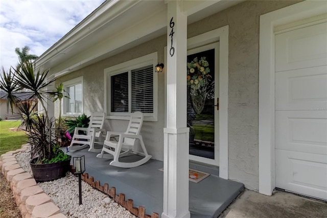 view of exterior entry featuring covered porch