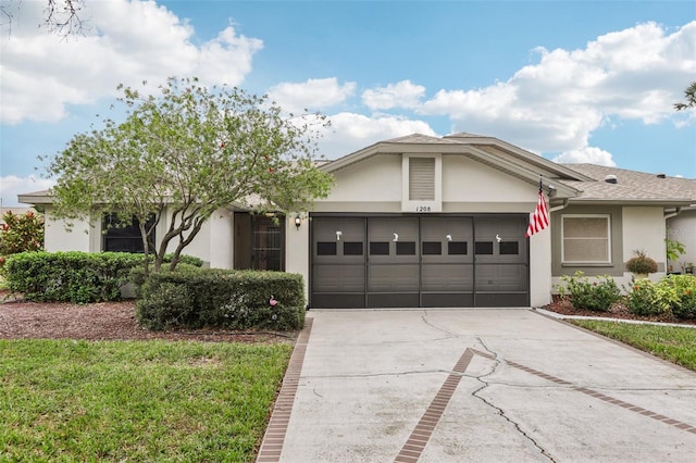 single story home with a garage and a front lawn