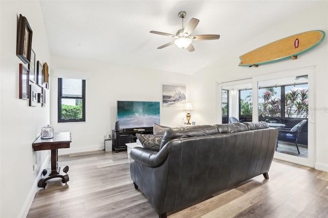 living room with ceiling fan, light hardwood / wood-style flooring, and lofted ceiling