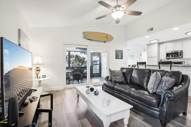 living room with ceiling fan, lofted ceiling, french doors, and dark hardwood / wood-style floors