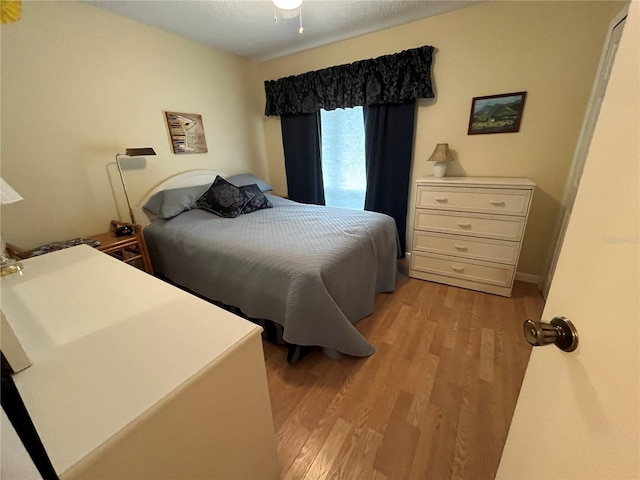 bedroom featuring light hardwood / wood-style floors and a textured ceiling