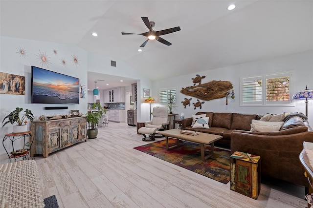 living room featuring light wood-type flooring, lofted ceiling, a healthy amount of sunlight, and ceiling fan