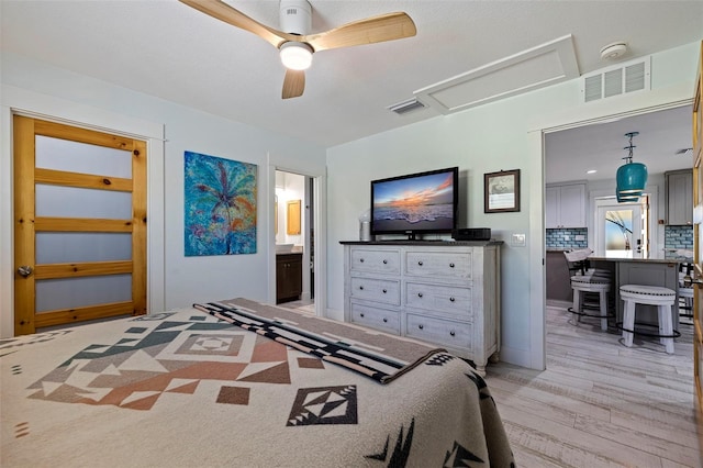 bedroom featuring light hardwood / wood-style flooring, ceiling fan, and ensuite bath