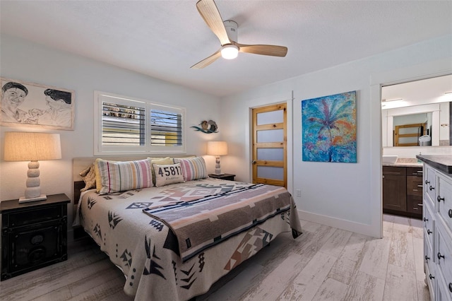 bedroom featuring ensuite bathroom, ceiling fan, and light wood-type flooring