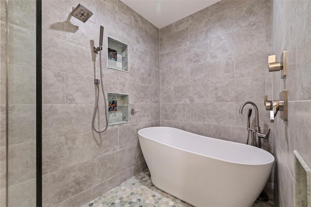 bathroom featuring shower with separate bathtub, tile walls, and tile patterned floors