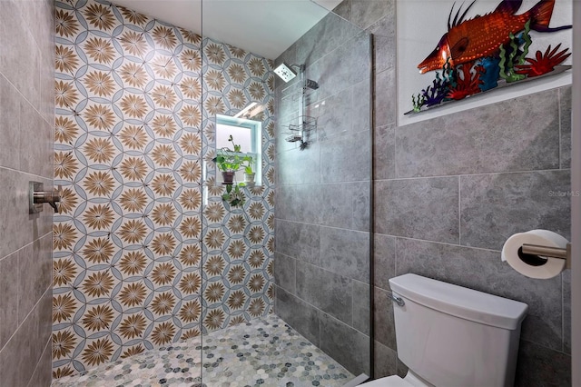 bathroom with toilet and a tile shower