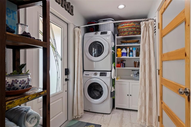 laundry room featuring stacked washer and dryer and light hardwood / wood-style flooring