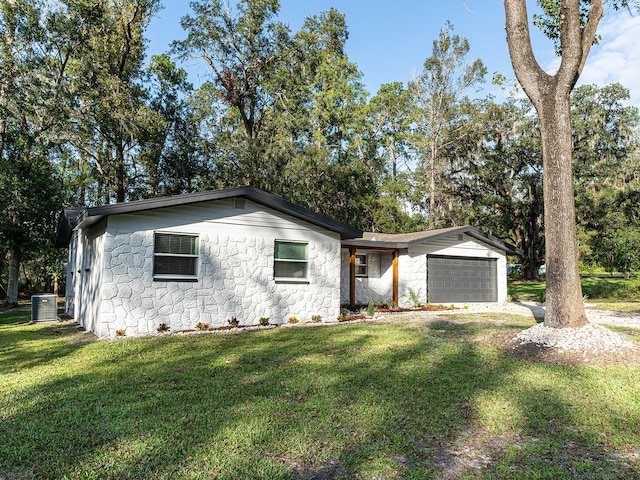 ranch-style house featuring a garage, a front yard, and central AC