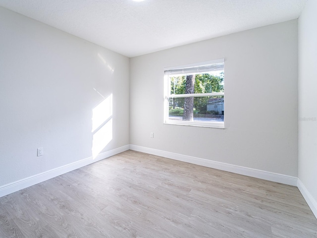 unfurnished room featuring light hardwood / wood-style floors and a textured ceiling