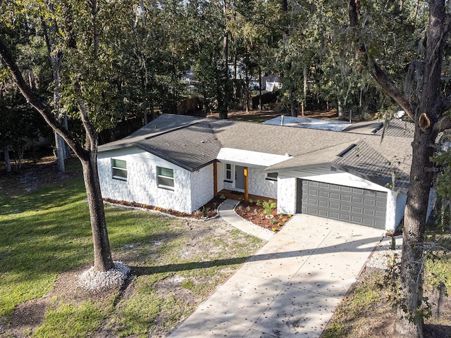 ranch-style home featuring a garage and a front yard