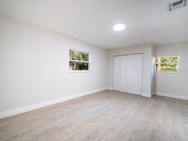 unfurnished bedroom featuring a closet and light wood-type flooring