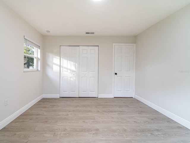 unfurnished bedroom with a closet and light hardwood / wood-style flooring