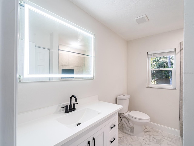 bathroom with toilet, vanity, and a textured ceiling