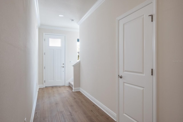 entryway with light hardwood / wood-style flooring and crown molding