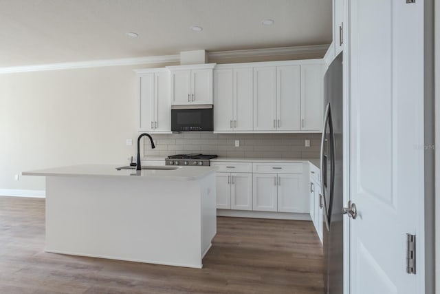 kitchen featuring sink, a kitchen island with sink, stainless steel refrigerator, and white cabinetry