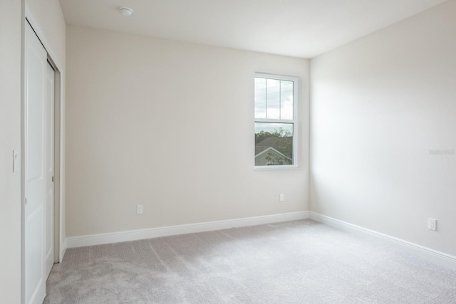 unfurnished bedroom with a closet and light carpet