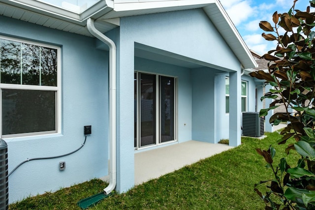 view of side of home with a yard and central AC unit