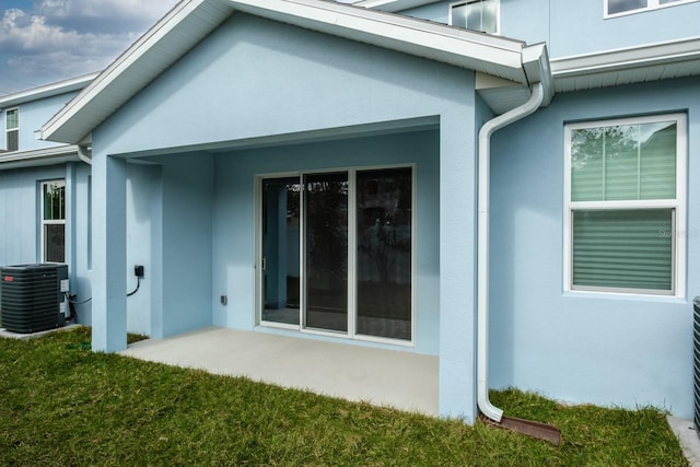 rear view of house with a patio, central AC, and a yard