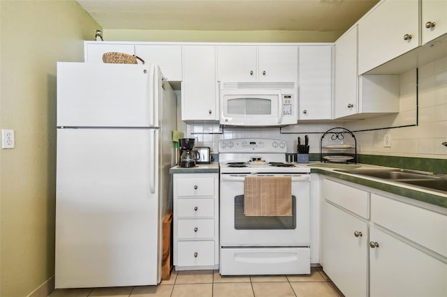 kitchen featuring white appliances, white cabinetry, light tile patterned floors, and backsplash