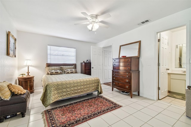 tiled bedroom with ceiling fan and ensuite bath