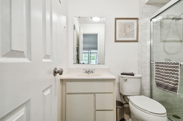 bathroom featuring vanity, toilet, and a shower with door