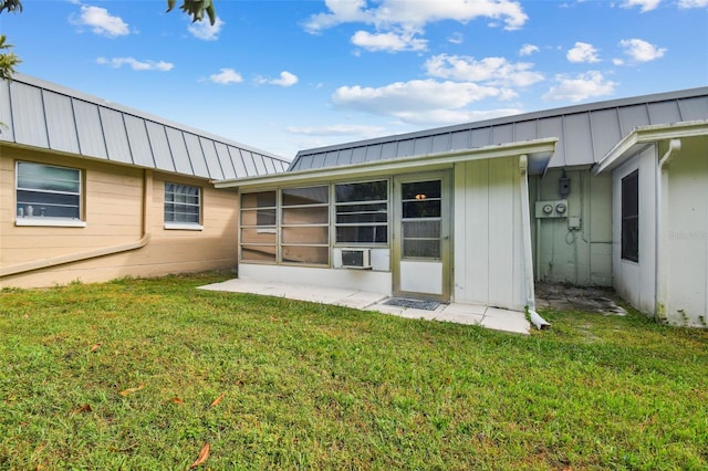 rear view of property featuring a sunroom and a yard