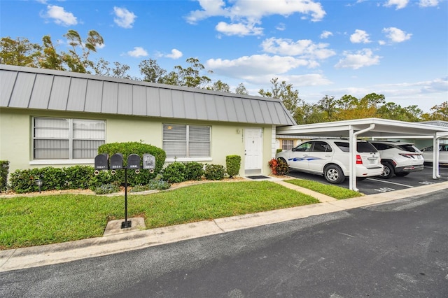 view of front of home featuring a front yard and a carport