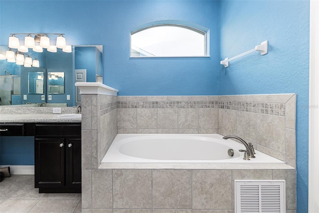 bathroom featuring vanity, tiled bath, and tile patterned floors