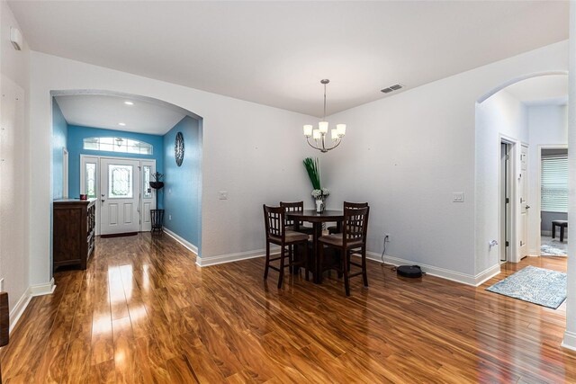 dining room featuring dark wood-type flooring and a chandelier