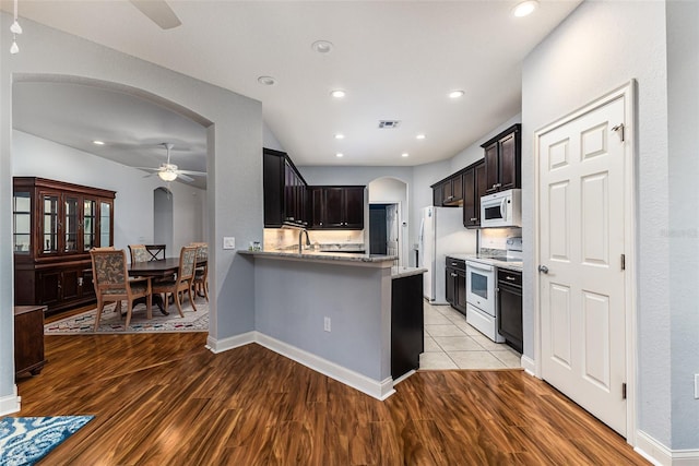 kitchen featuring kitchen peninsula, white appliances, ceiling fan, and light hardwood / wood-style floors