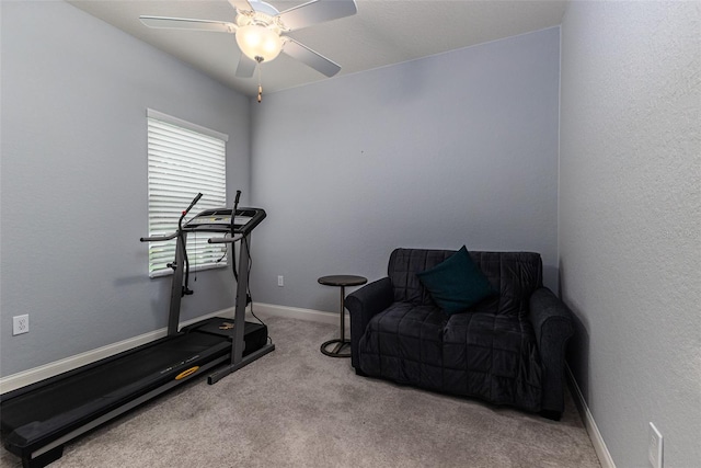 workout room with ceiling fan and light colored carpet