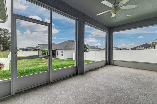 unfurnished sunroom featuring ceiling fan