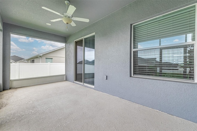 unfurnished sunroom with ceiling fan