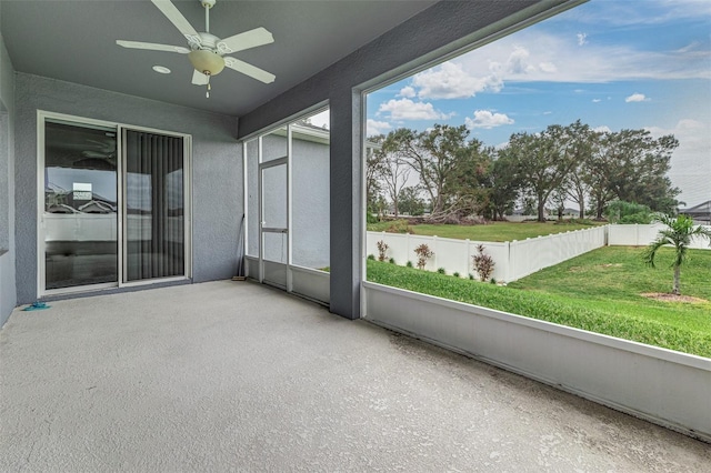 unfurnished sunroom with a wealth of natural light and ceiling fan