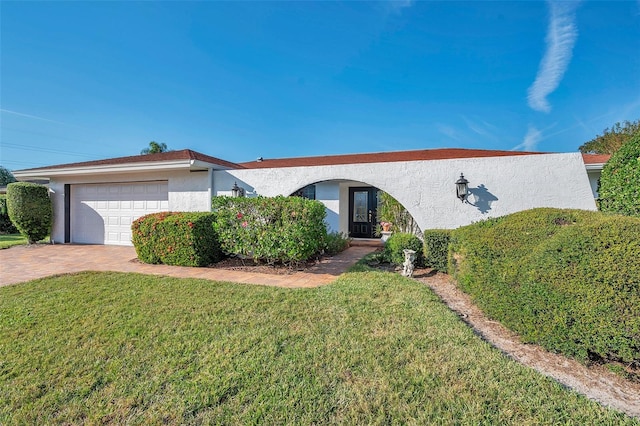 single story home featuring a garage and a front lawn