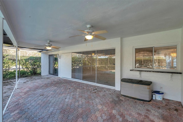 unfurnished sunroom with ceiling fan