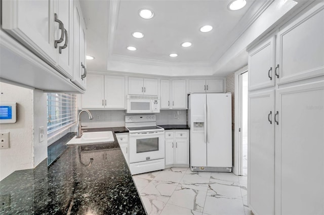 kitchen featuring white appliances, white cabinetry, sink, and a raised ceiling