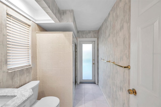 bathroom with tile walls, tile patterned flooring, and plenty of natural light