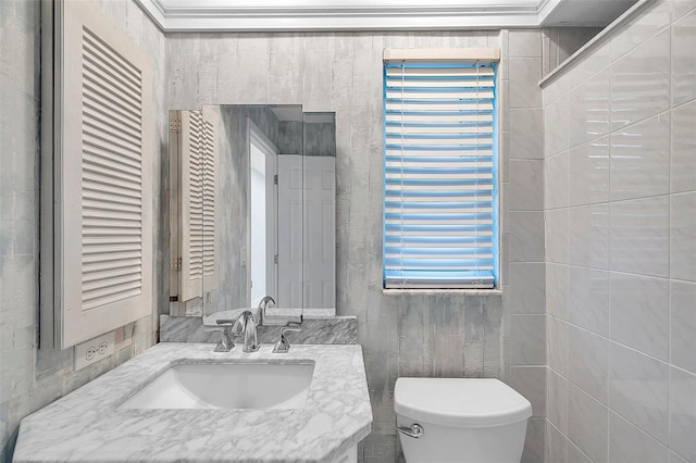 bathroom with vanity, toilet, and ornamental molding