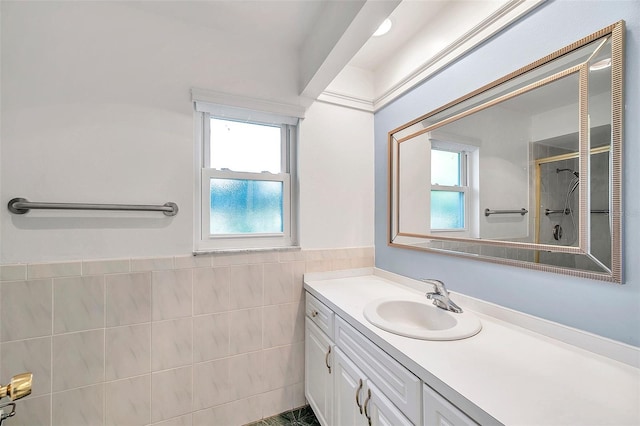 bathroom with walk in shower, vanity, and tile walls