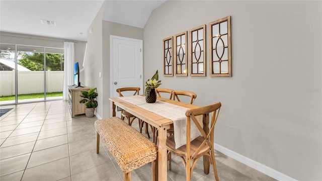 dining area featuring lofted ceiling and light tile patterned floors