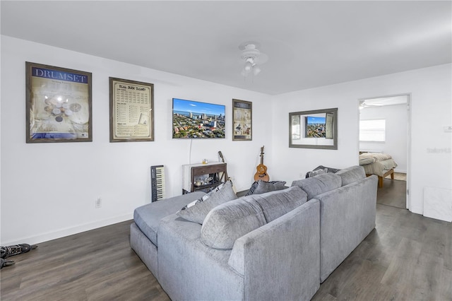 living room featuring ceiling fan and dark hardwood / wood-style floors