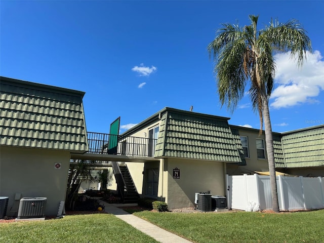 back of house featuring central AC and a yard