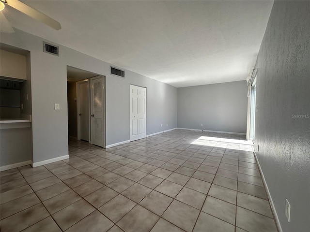 unfurnished room featuring light tile patterned floors and ceiling fan