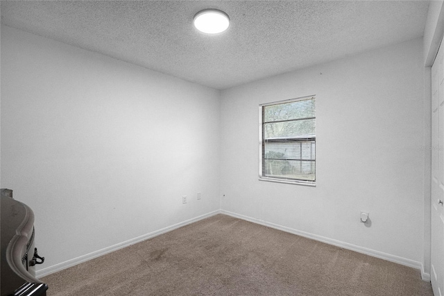 carpeted spare room featuring a textured ceiling