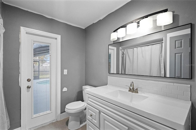 bathroom with tile patterned floors, vanity, toilet, and backsplash