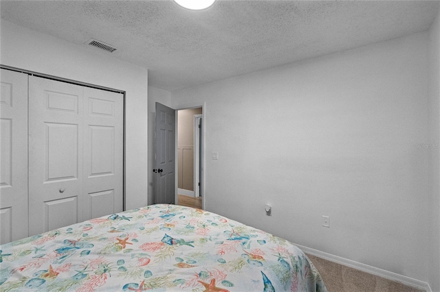 bedroom featuring carpet, a textured ceiling, and a closet