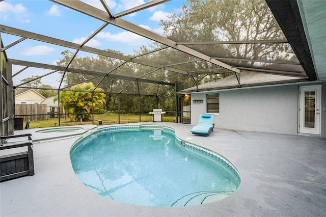 view of swimming pool featuring glass enclosure, an in ground hot tub, and a patio