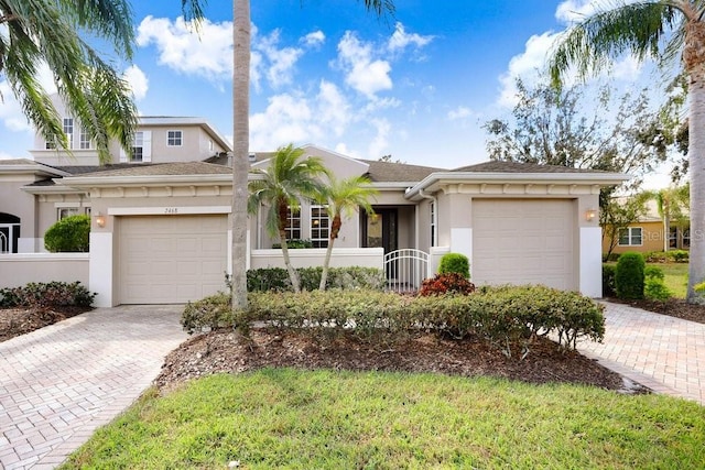 single story home with a garage, decorative driveway, and stucco siding